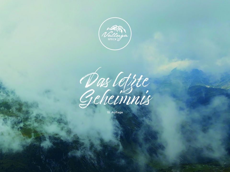 Berggipfel im Nebel im Hintergrund. Darauf das Valluga-Speck-Signet, der Titel "Das letzte Geheimnis" und der Hinweis, dass es sich um die 15. Auflage handelt.